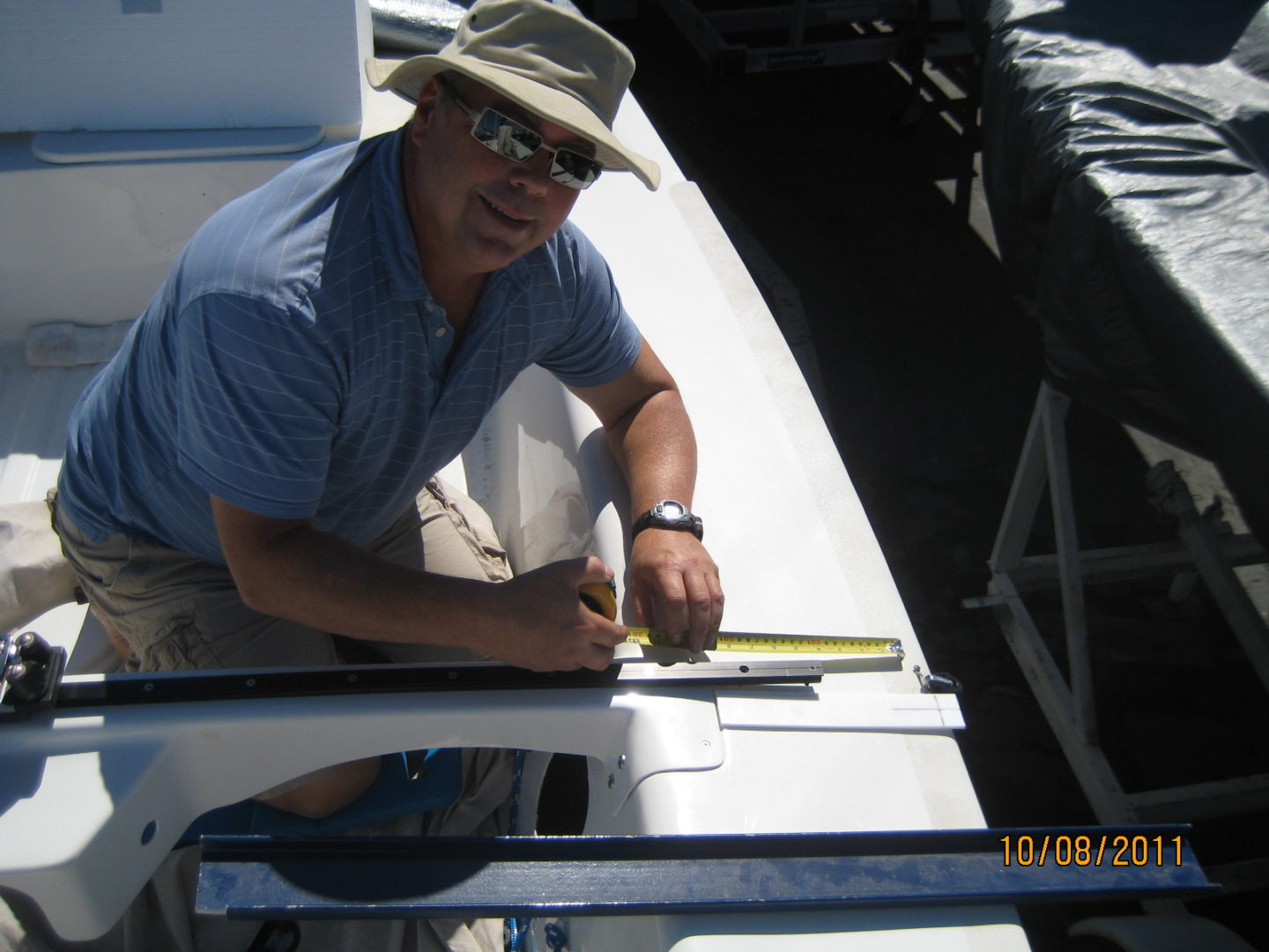 A man in hat and glasses working on a boat.