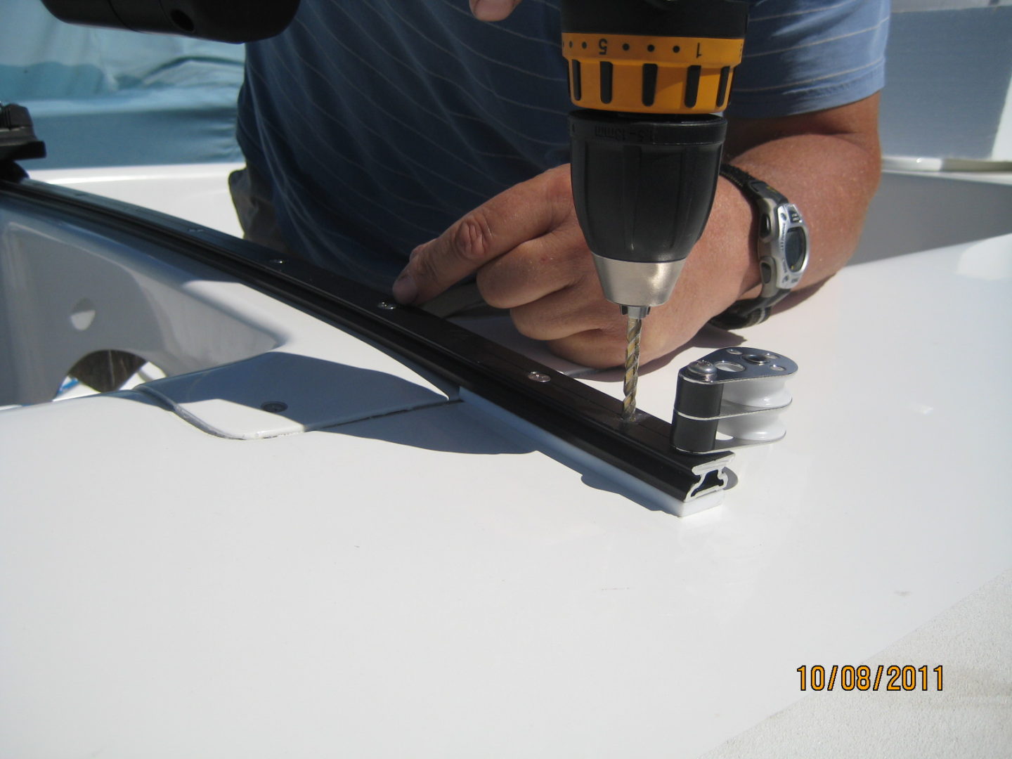 A man using a drill to install the antenna.