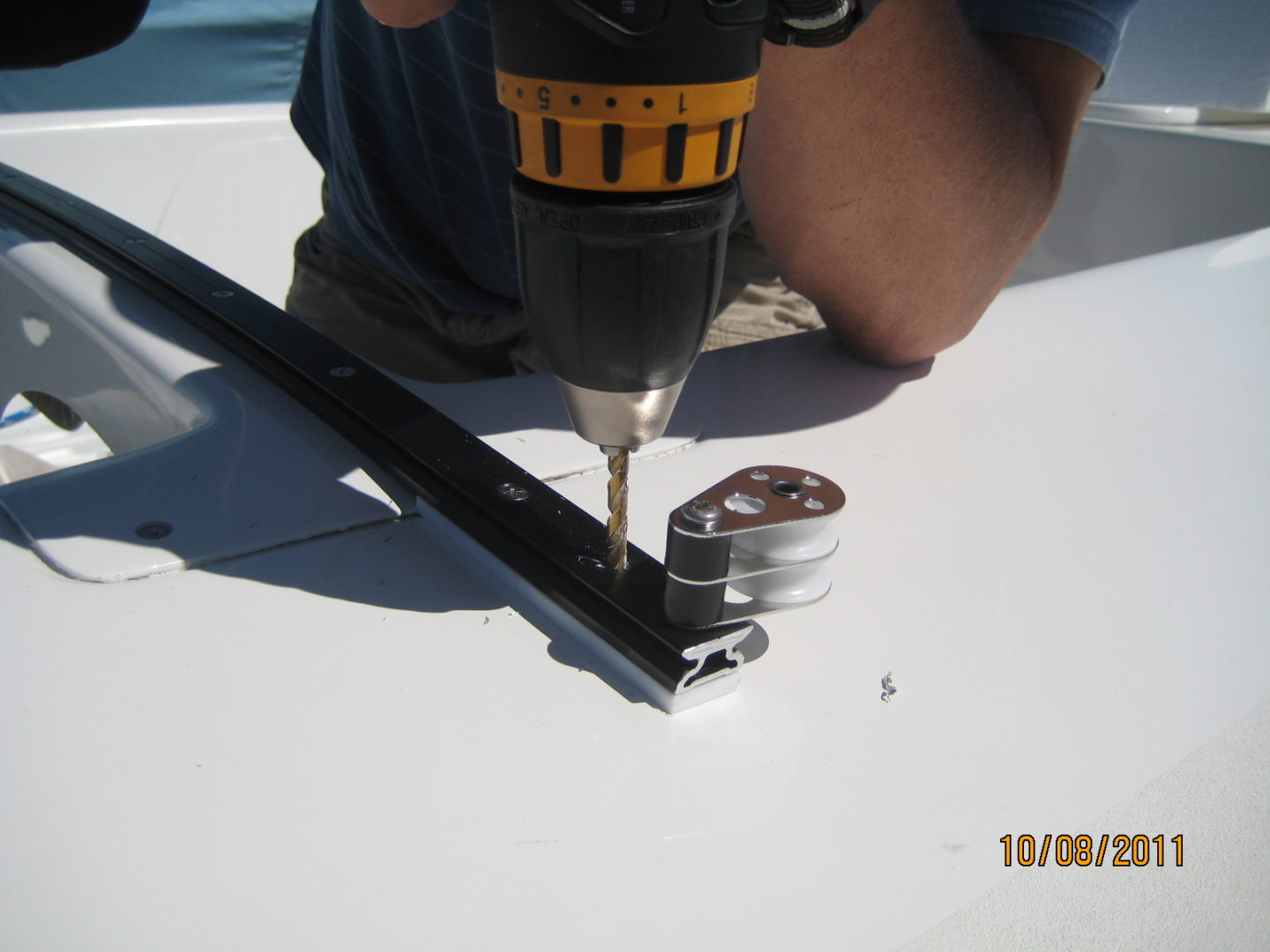 A person using a drill to make holes in the ground.