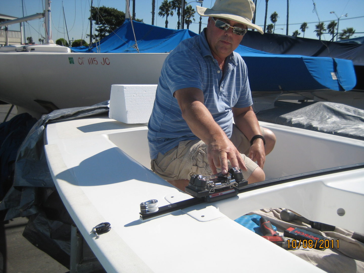 A man sitting on top of a boat with fishing rods.