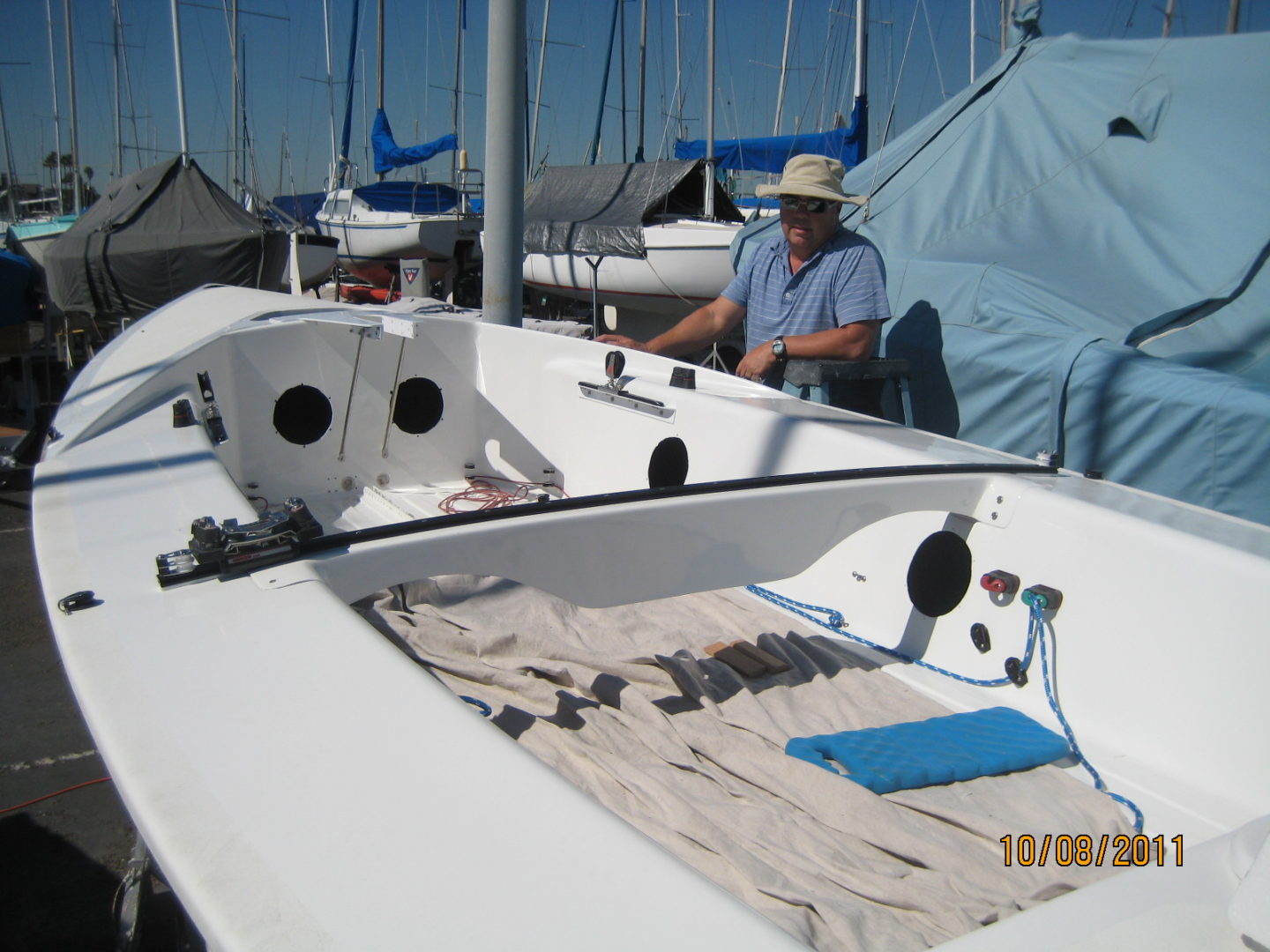 A man standing next to a boat on the water.