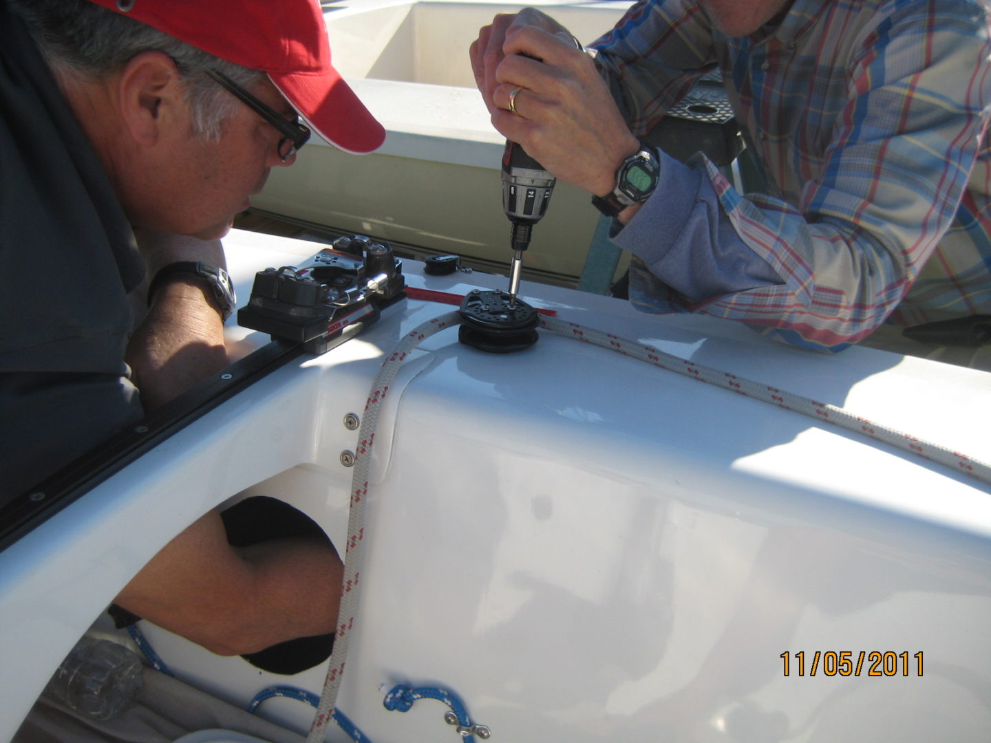 Two men working on a boat in the water.