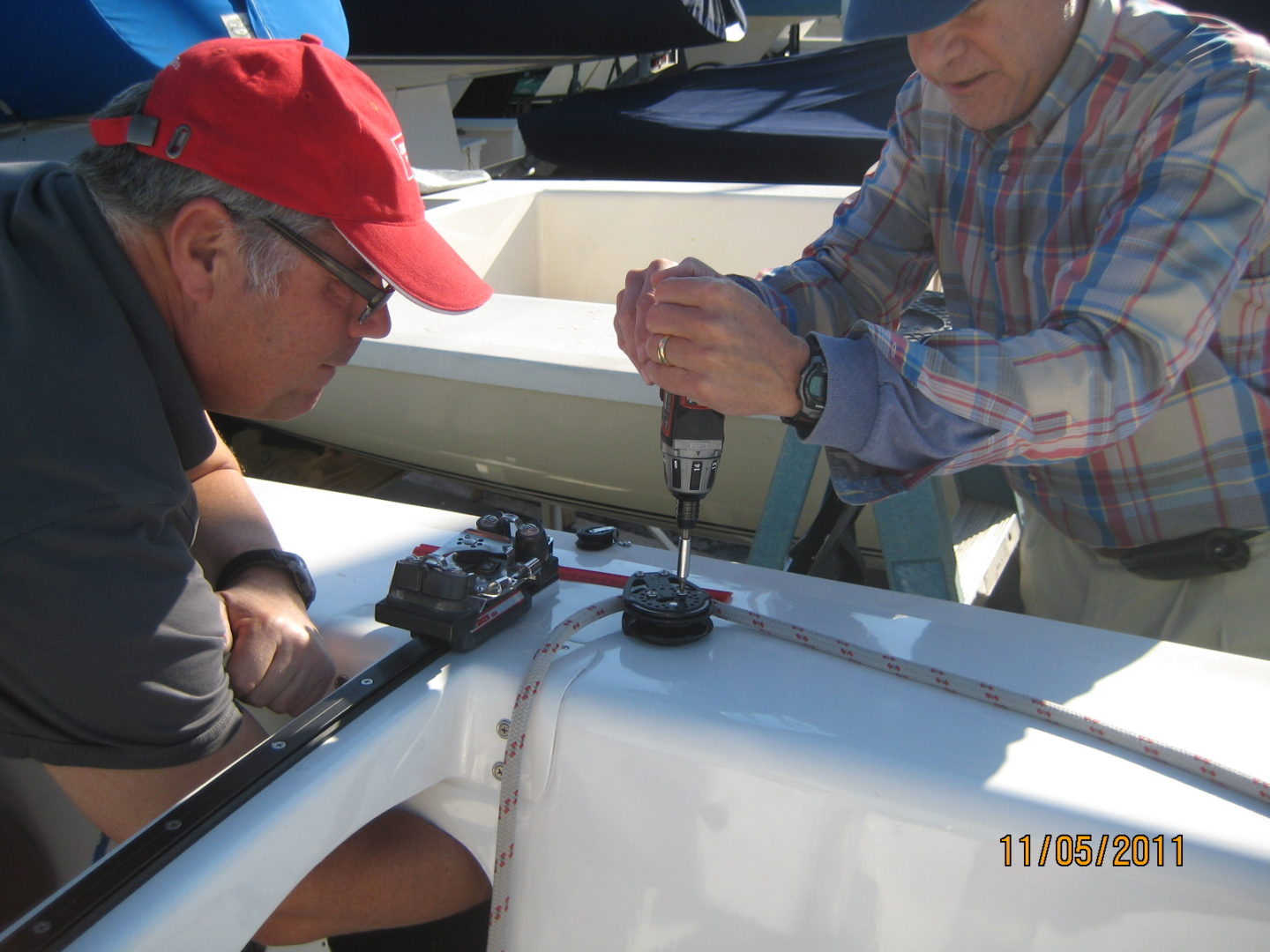 Two men working on a boat in the water.