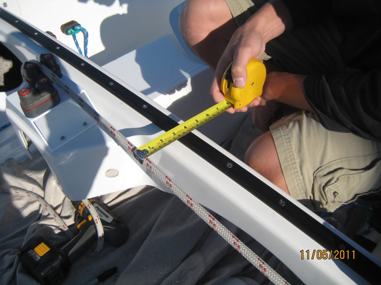 A man is measuring the length of a boat.