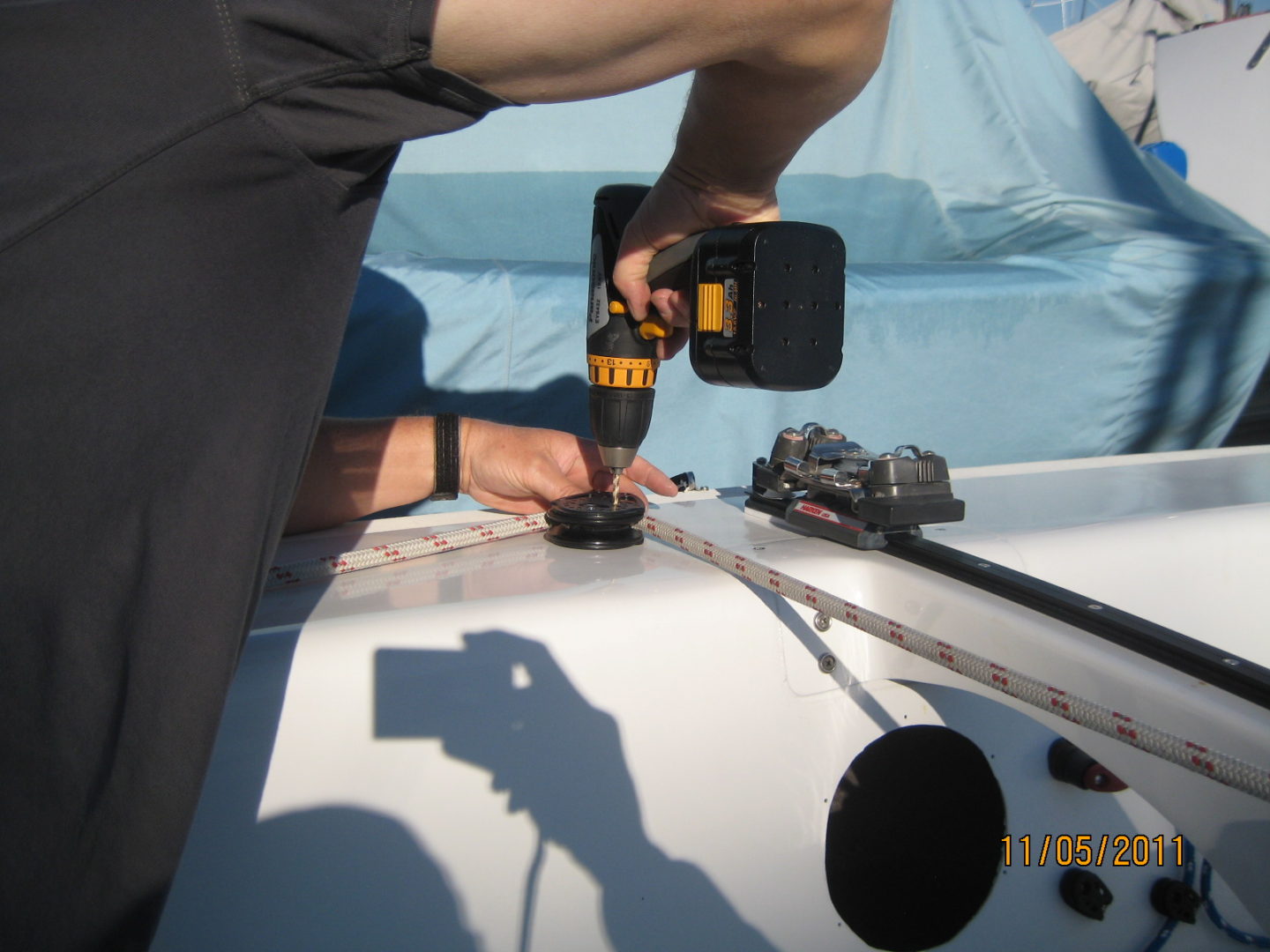 A man using a drill to install the antenna.