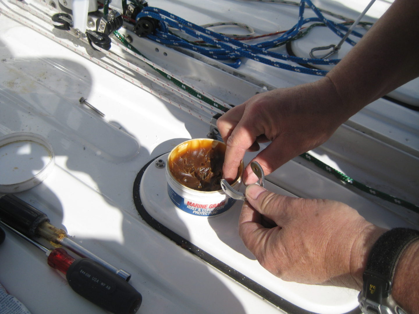 A person is holding a cup of coffee on the boat.