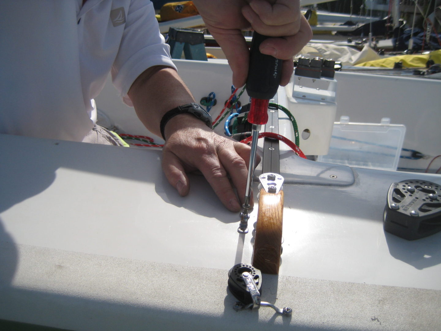 A person using a drill to install an electrical device.