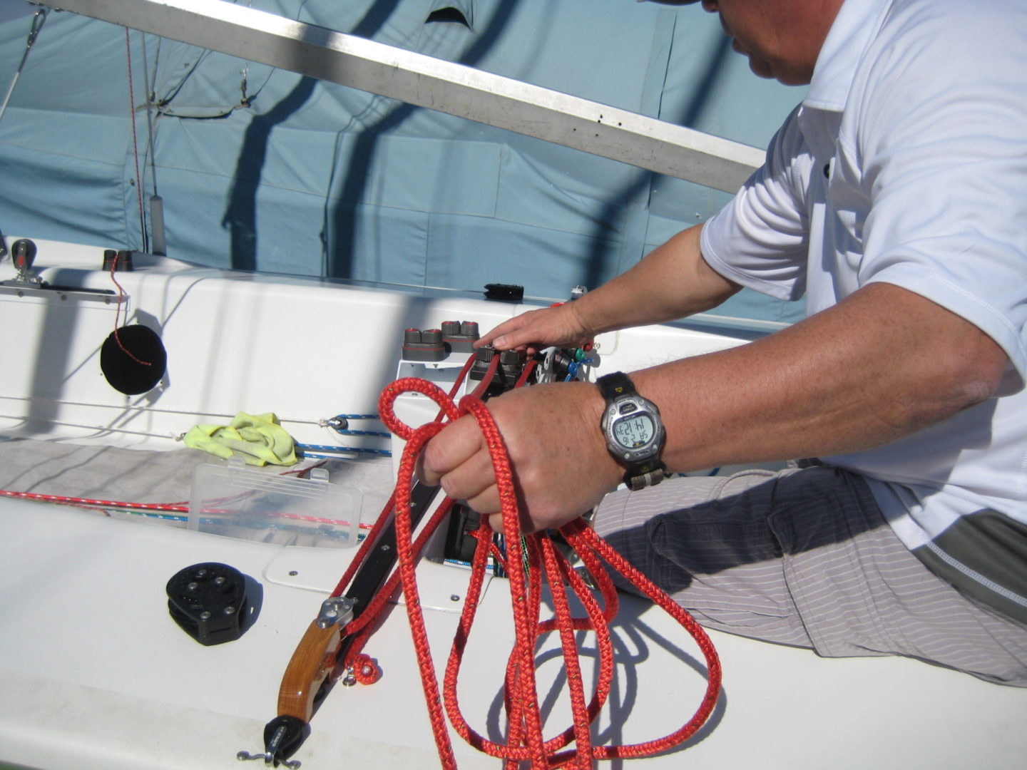 A man is holding some red cords on the boat